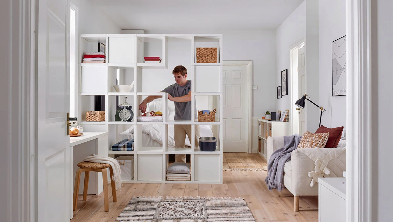 Room divider + storage in a open-concept small apartment studio apartment main using stackable cube units