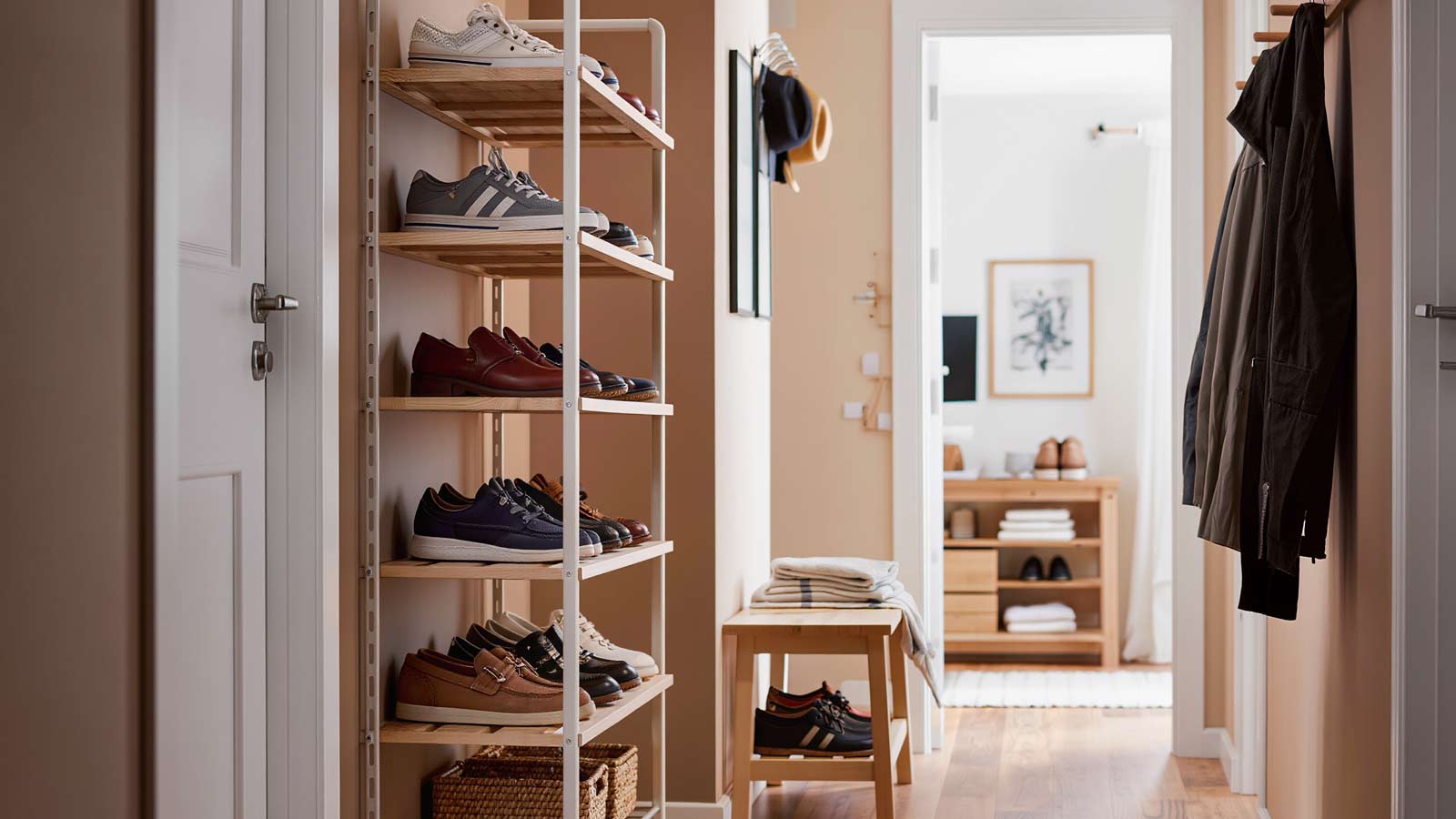Small studio apartment entryway hallway featuring a tiered shoe rack used for organized shoe storage in a compact space